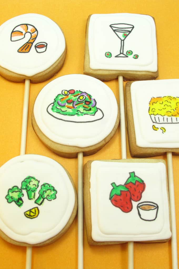 Dinner cookies: How to use food coloring pens to draw "dinner" on royal icing topped cookies on a stick.