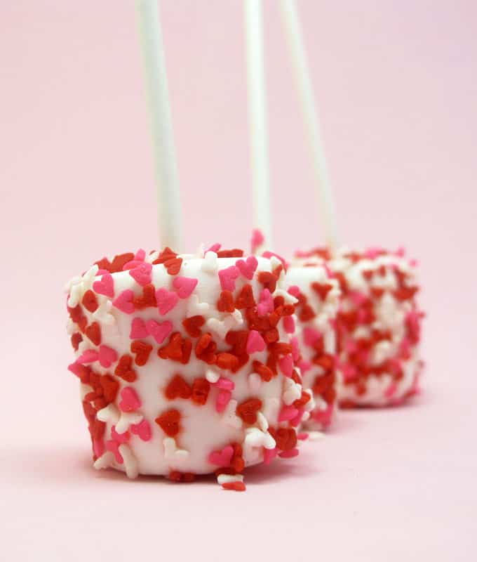 Heart sprinkle marshmallows and cookies with royal icing for easy Valentine's Day treats. 