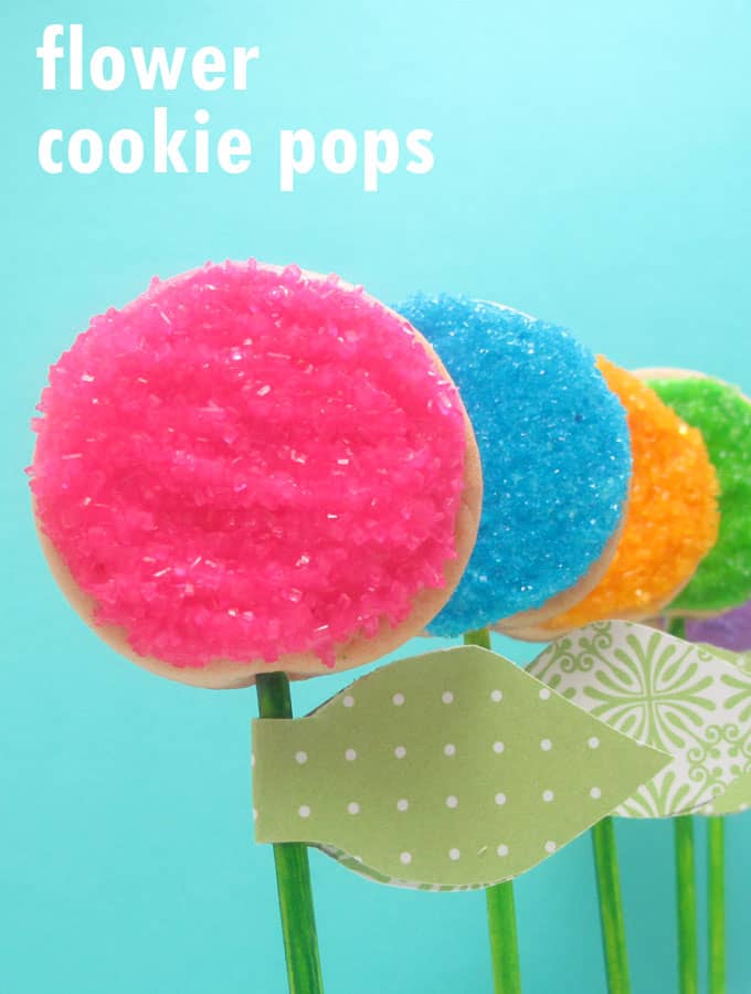 How to decorate easy flower cookie pops using sprinkles. Attach paper leaves to make place cards or party favors for a spring or garden party.