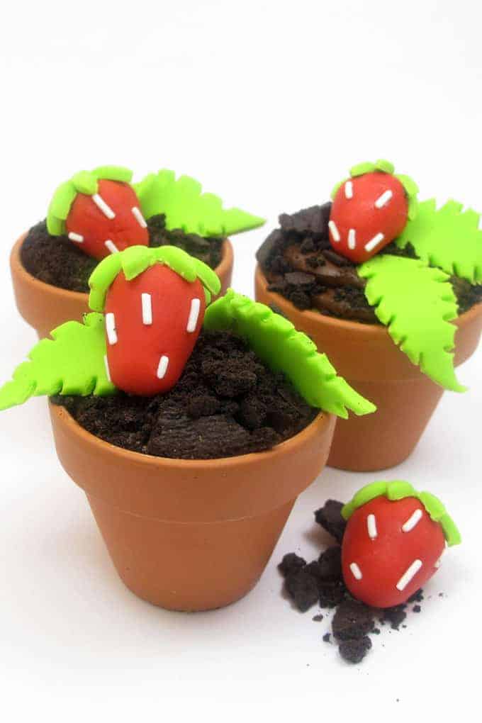 Strawberry patch cupcakes are delicious chocolate "dirt" cupcakes in flower pots with strawberry patch fondant decorations. #strawberry #summer #cupcakes #flowerpot #Fondant 