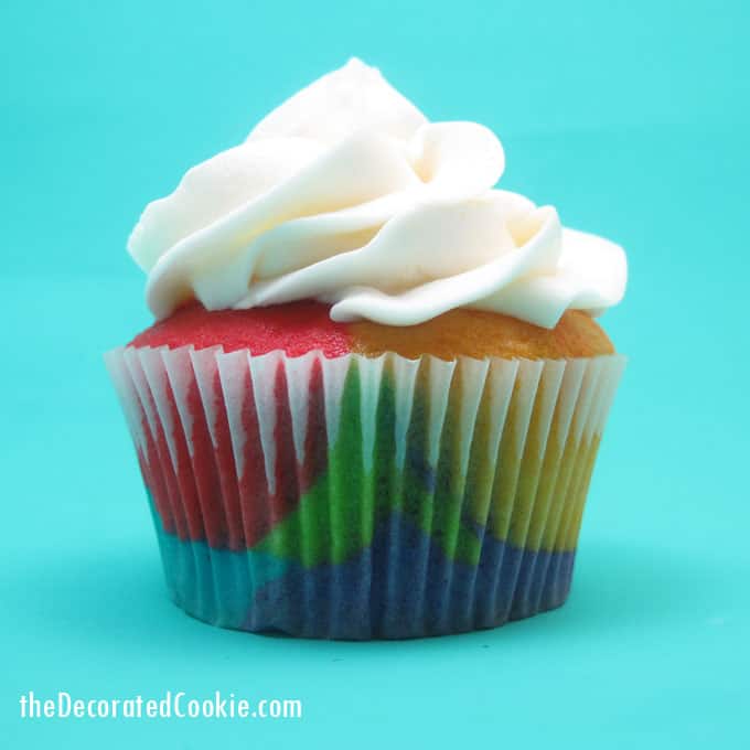 Rainbow cake and cupcakes with buttercream frosting for a unicorn or rainbow party -- the decorated cookie 