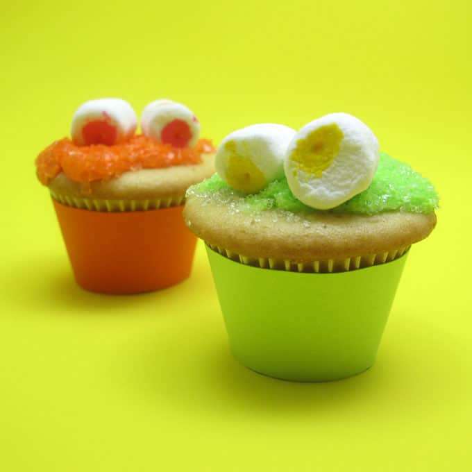 Mini monster cupcakes for a fun Halloween food idea -- marshmallow googly-eyes top sparkly cupcakes. Easy cupcake decorating.