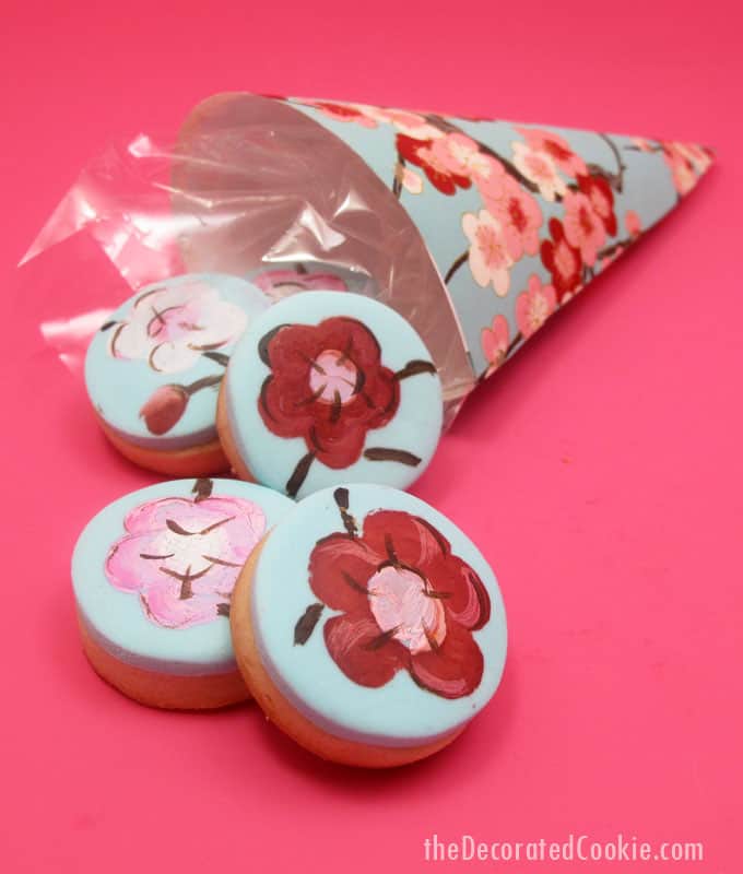How to make painted cherry blossom decorated cookies in paper cones for beautiful spring party favors.  #papercones #weddingfavors #paintedcookies #cherryblossoms #flowers #partyfavors #fondant #spring