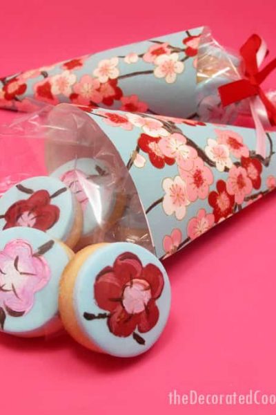 How to make painted cherry blossom decorated cookies in paper cones for beautiful spring party favors.  #papercones #weddingfavors #paintedcookies #cherryblossoms #flowers #partyfavors #fondant #spring