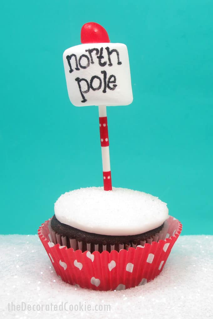 Super simple North Pole cupcakes for a cute and easy Christmas treat. Cupcakes, white frosting, a lollipop stick, marshmallow, food writer, and candy.