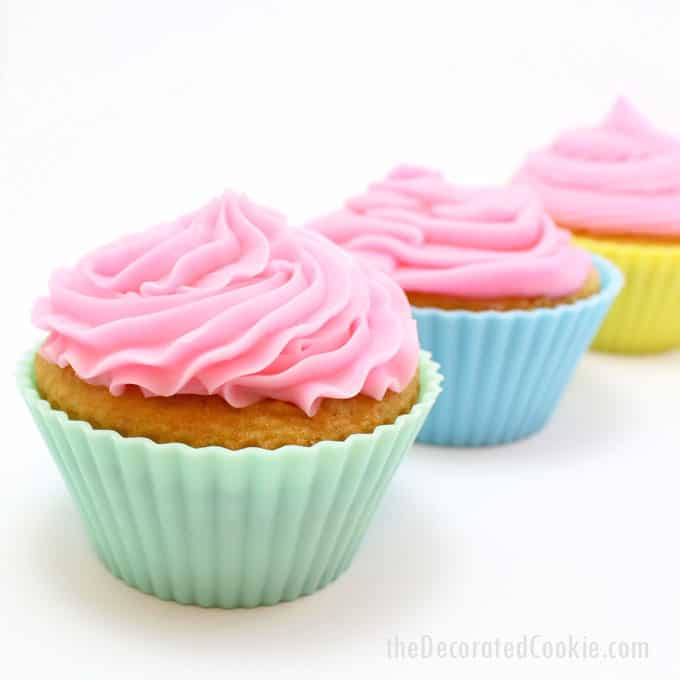 piping frosting on cupcakes