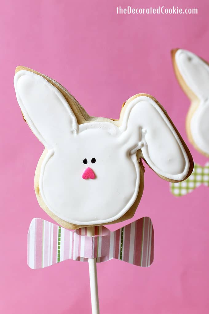 Decorated EASTER BUNNY COOKIES on a stick wearing paper bow ties. How to decorate cookies for Easter with step-by-step instructions. 