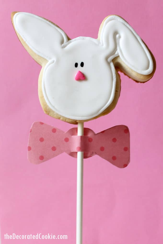 Decorated EASTER BUNNY COOKIES on a stick wearing paper bow ties. How to decorate cookies for Easter with step-by-step instructions. 