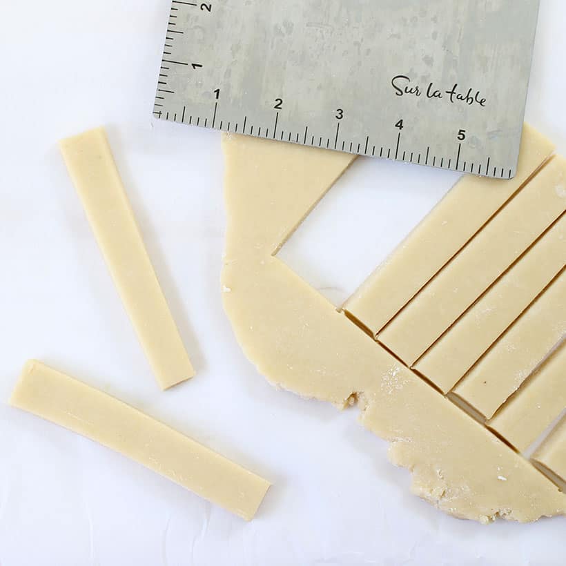 cutting out turkey cookie sticks from rolled out cookie dough