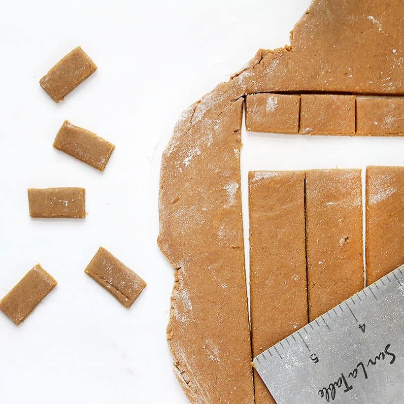 cutting out tiny gingerbread cookie rectangles 