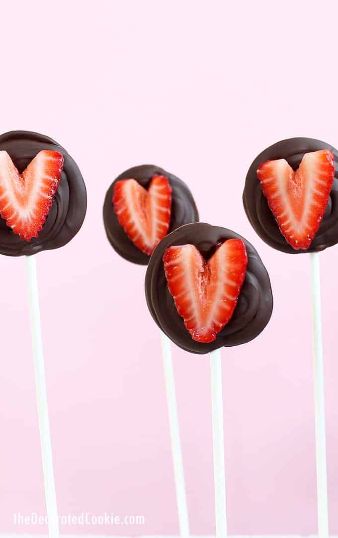 CHOCOLATE STRAWBERRY HEARTS on a stick for Valentine's Day. Chocolate covered strawberries, but easier to eat and make and much cuter. #valentinesday #strawberries #chocolate #lollipops