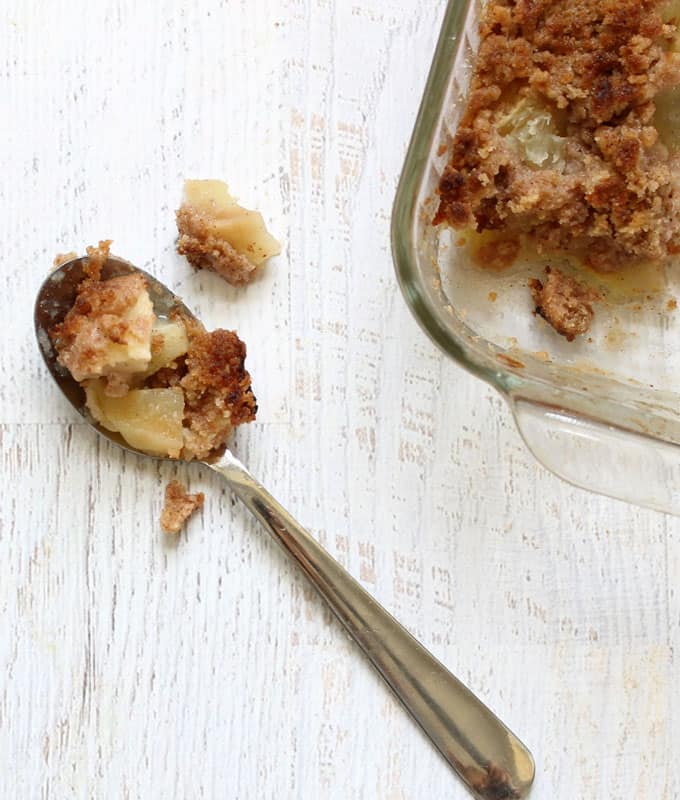 apple crisp on spoon and in baking dish 