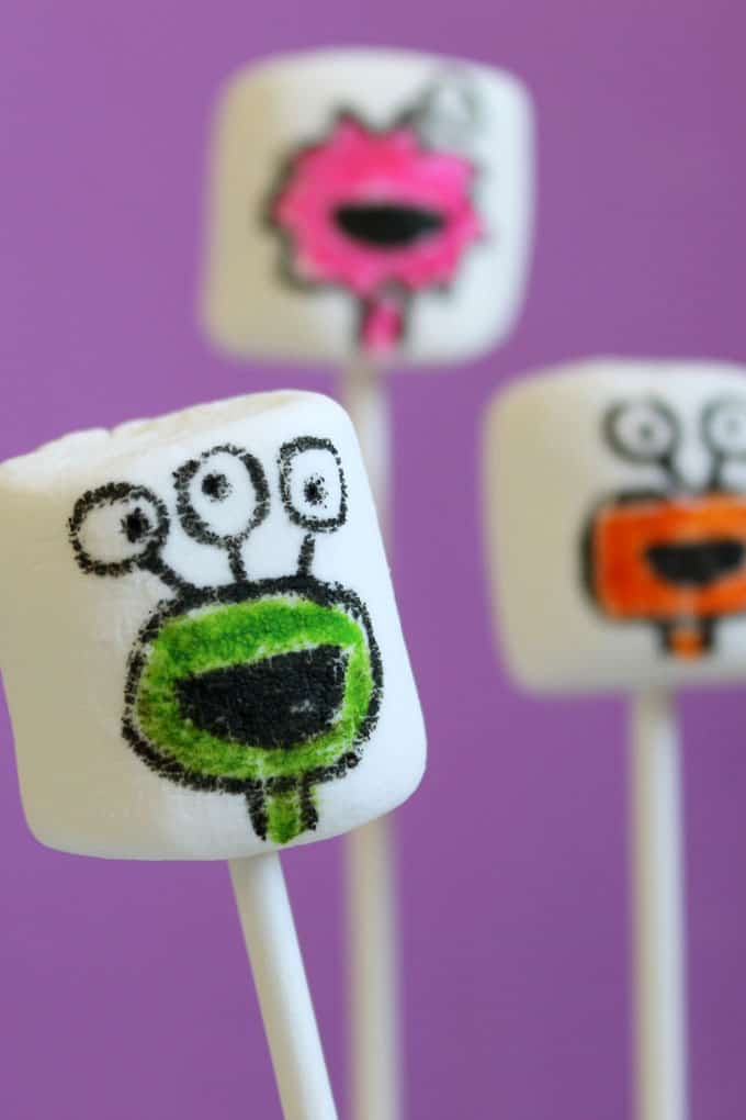 Monster marshmallows for Halloween. Use food coloring pens and marshmallows to create marshmallow art for an easy Halloween treat idea kids can make.