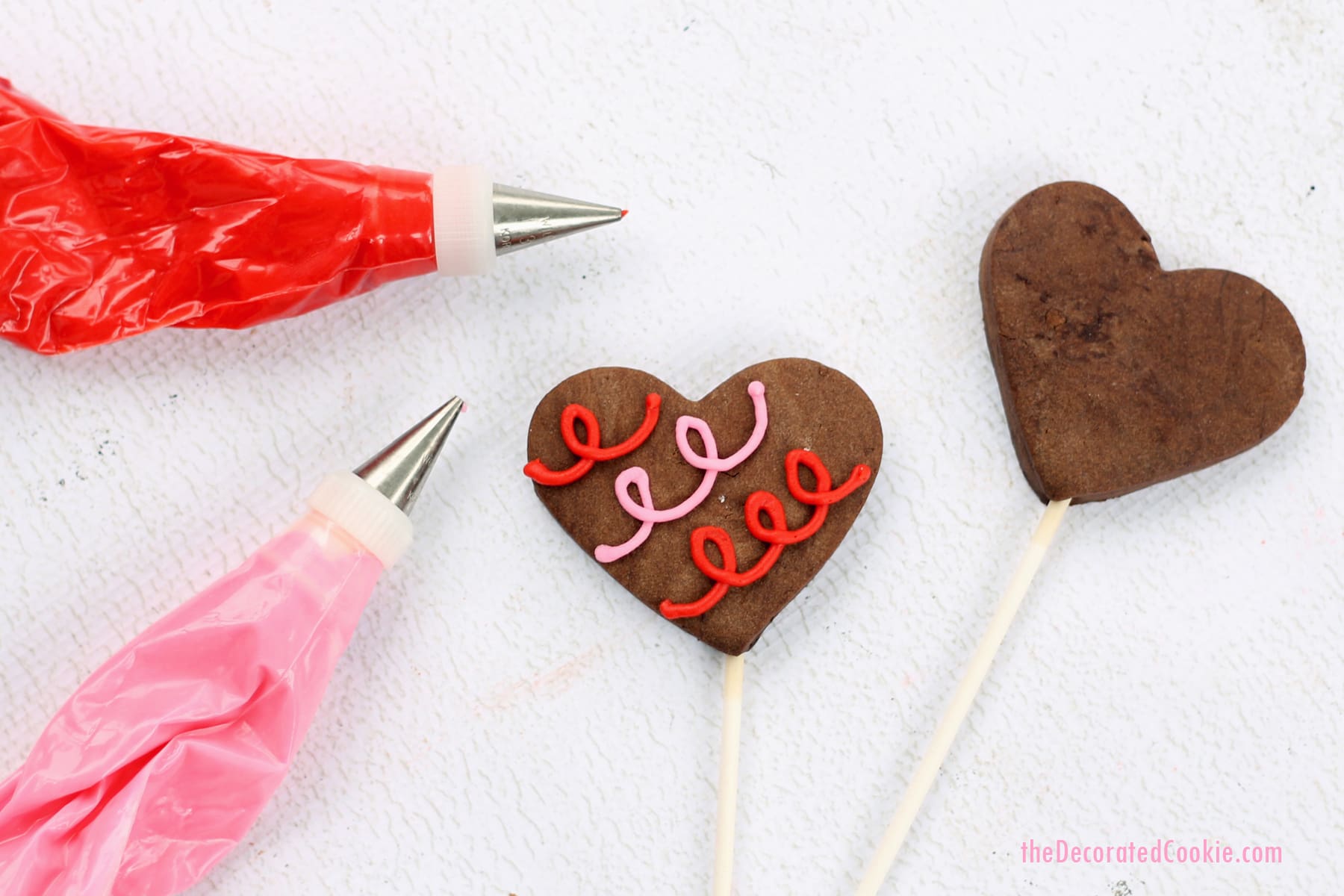 chocolate heart cookie pops with orange buttercream frosting 