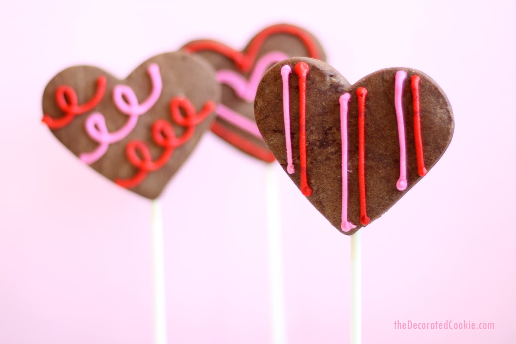 chocolate heart cookie pops with orange buttercream frosting 