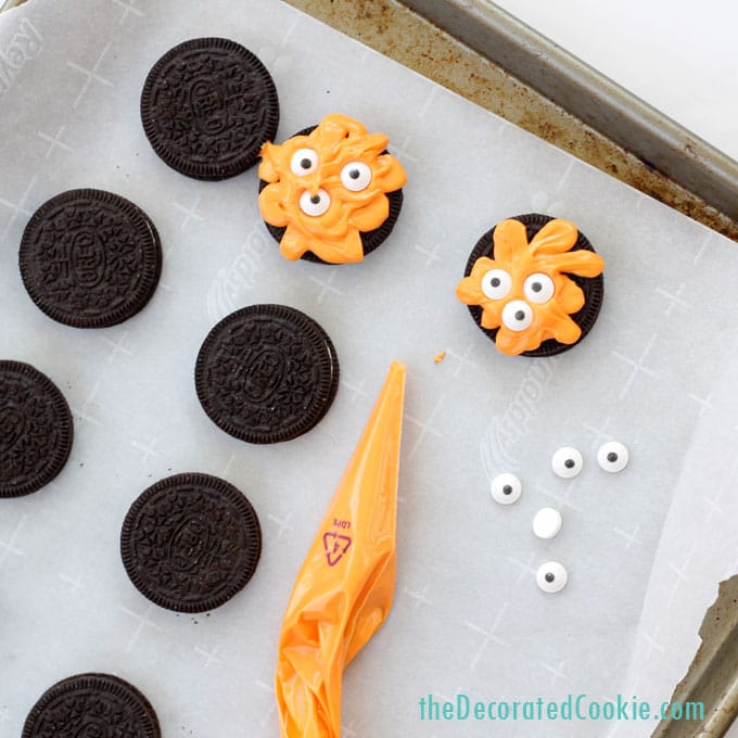 making orange monster cookies using melted orange candy melts, OREO cookies, and candy eyes. 