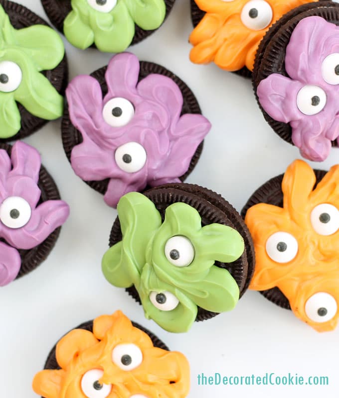 orange, purple, and green monster Oreo cookies with candy eyes