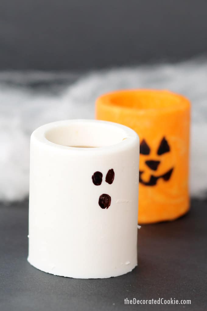 Chocolate ghosts and Jack O' Lantern edible Halloween shot glasses or treat cups to make your Halloween party extra fun -- Halloween party drinks. #candyshotglasses #edibleshotglasses #halloween #partyfood #partydrinks #halloweendrinks #chocolate #ghosts #jackolantern 