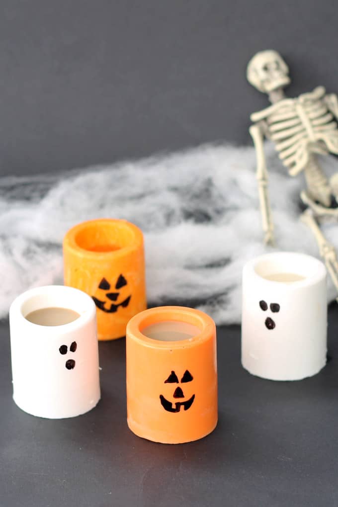 Chocolate ghosts and Jack O' Lantern edible Halloween shot glasses or treat cups to make your Halloween party extra fun -- Halloween party drinks. #candyshotglasses #edibleshotglasses #halloween #partyfood #partydrinks #halloweendrinks #chocolate #ghosts #jackolantern 