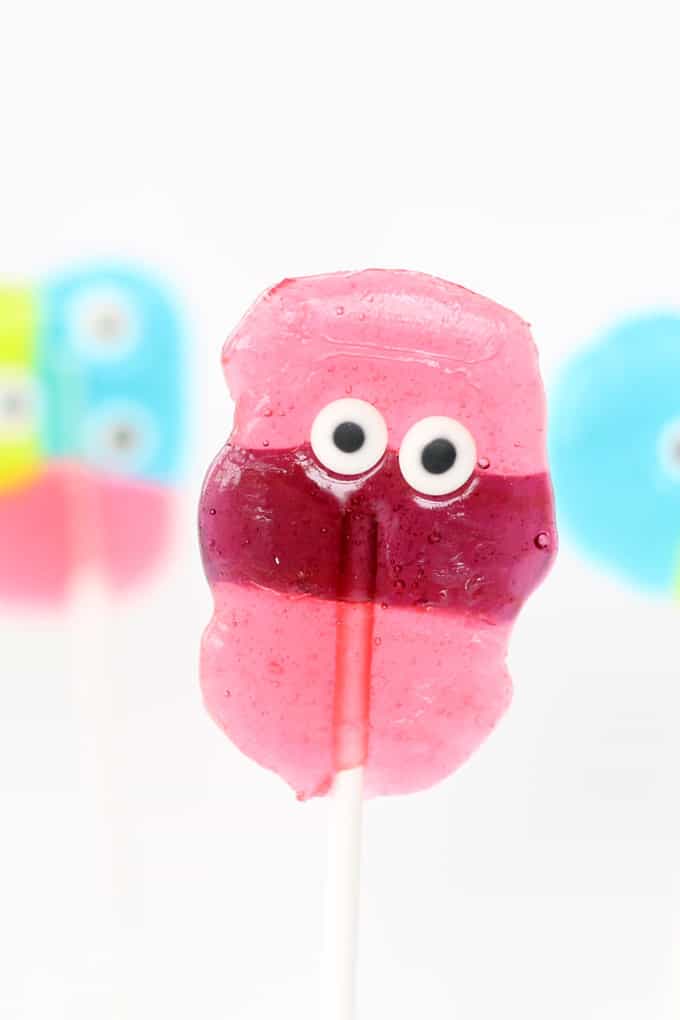 Simple monster Jolly Rancher lollipops are a kid-friendly fun Halloween party food or monster party treat. Easy to make using hard candy and candy eyes. #Halloween #jollyrancher #lollipops #monster 