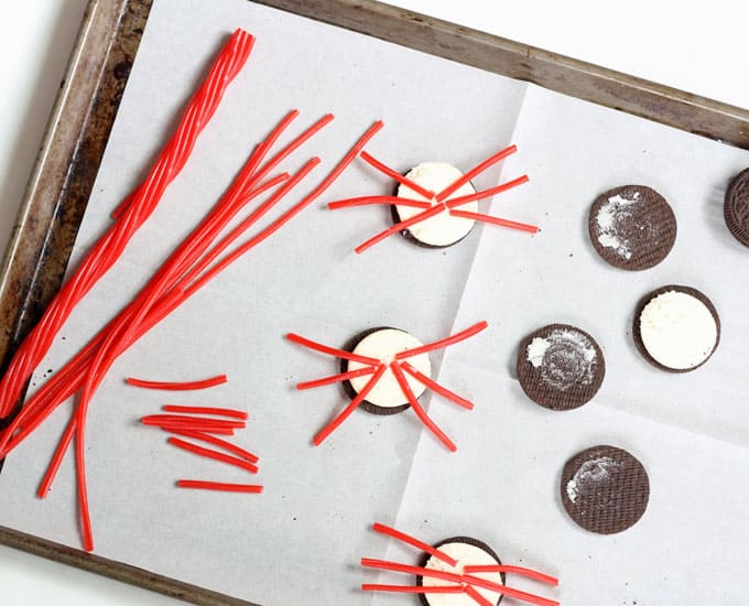 making Oreo crabs with red candy melts and licorice legs