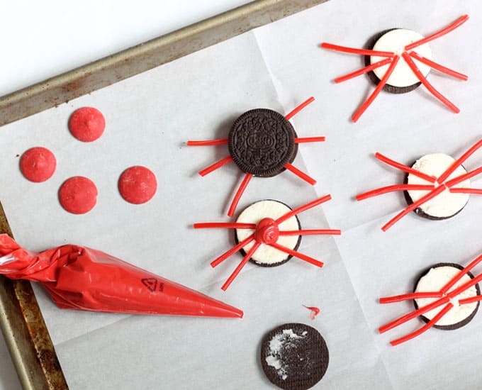 making Oreo crabs with red candy melts and licorice legs