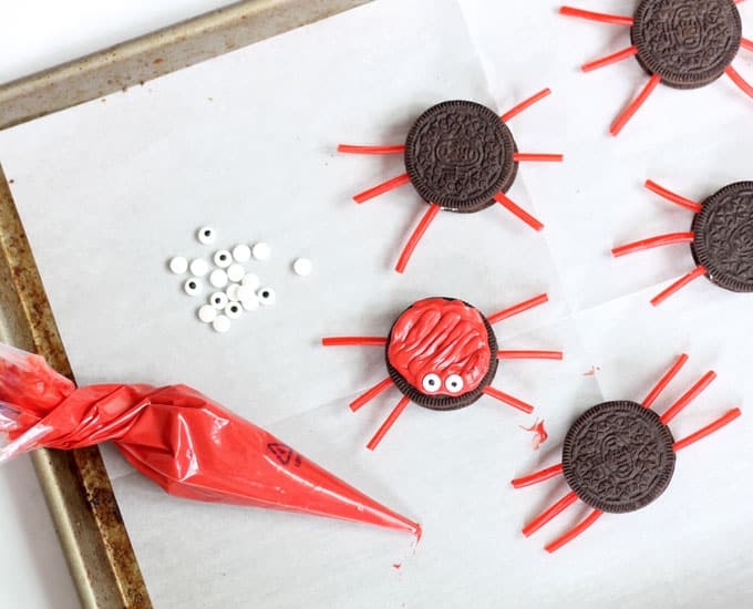 making Oreo crabs with red candy melts and licorice legs 