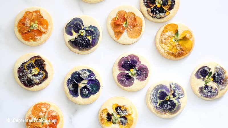 These gorgeous orange cookies with edible flowers are delicately flavored with orange extract and topped with a sprinkle of sugar. For afternoon tea, a lovely gift, or just to enjoy, these floral cookies are just right. These cookies use Nielsen-Massey's Pure Vanilla Extract and Pure Orange Extract. (Sponsored by Nielson-Massey) #NielsenMasseyPartner