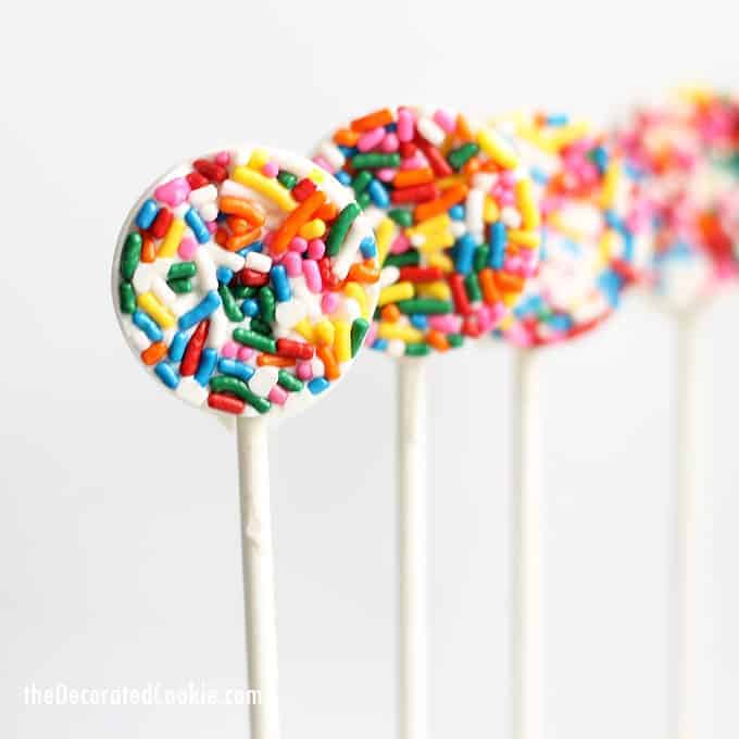 These easy sprinkle chocolate pops are a perfect fun food idea for birthday, unicorn, or rainbow parties. Or, for birthday party favors. Video how-tos. #chocolatepops #lollipops #sprinkles #birthday #partyfavors