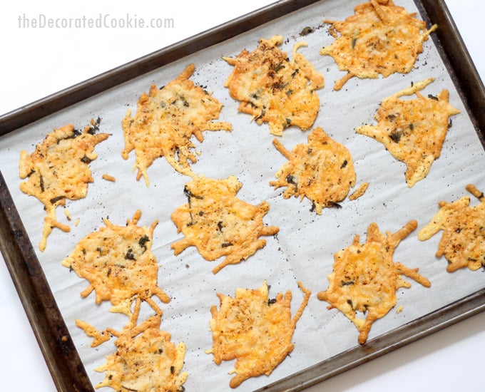 Parmesan crisps with herbs on baking tray
