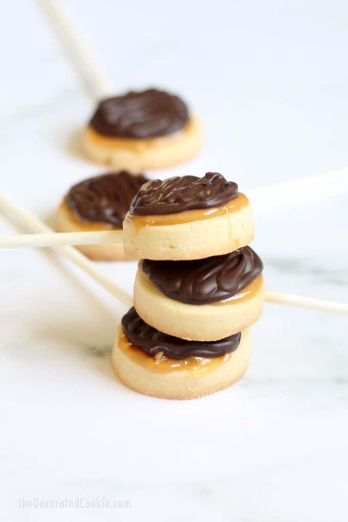 Twix cookies on a stick: Homemade Twix cookie pops are shortbread cookies, caramel, and chocolate, and even better than the classic candy bar. Video recipe. #Twix #HomemadeTwix #TwixCookies #CookiePops #CandyBarRecipes 