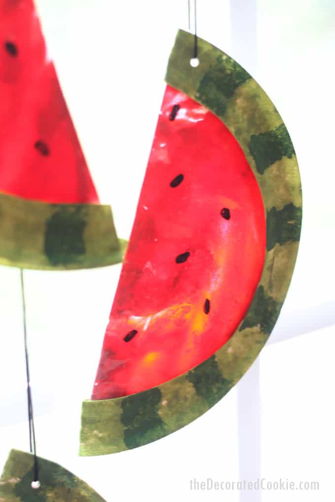 This watermelon suncatcher, made with melted crayons and paper plates, is a fun summer craft kids and adults can make together. #suncatcher #kidscraft #summercrafts #summer #watermelon 