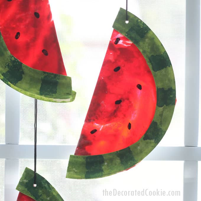 This watermelon suncatcher, made with melted crayons and paper plates, is a fun summer craft kids and adults can make together. #suncatcher #kidscraft #summercrafts #summer #watermelon