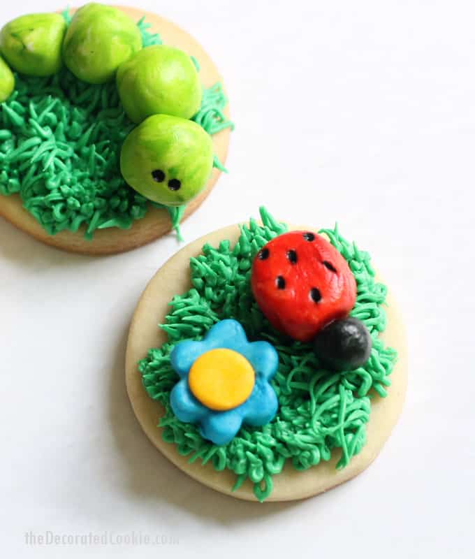 FROSTING CLAY: How to turn buttercream frosting into a delicious alternative to fondant. Sculptable frosting is perfect for cake and cookie decorating. Here, I made grass-topped decorated cookies with buttercream frosting clay BUGS and FLOWERS. #cookiedecorating #buttercreamfrosting #candyclay #fondant #cookies #bugs 