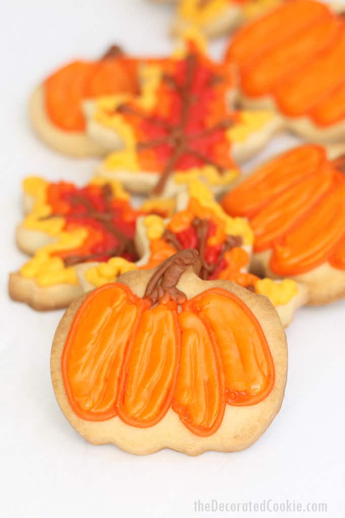 These pumpkin and leaf fall cookies are a fun food craft for autumn, Thanksgiving, school bake sales, and fall fests. #cookiedecorating #fallcookies #Thanksgiving #desserts #partyfavors #bakesale #pumpkins #leaf