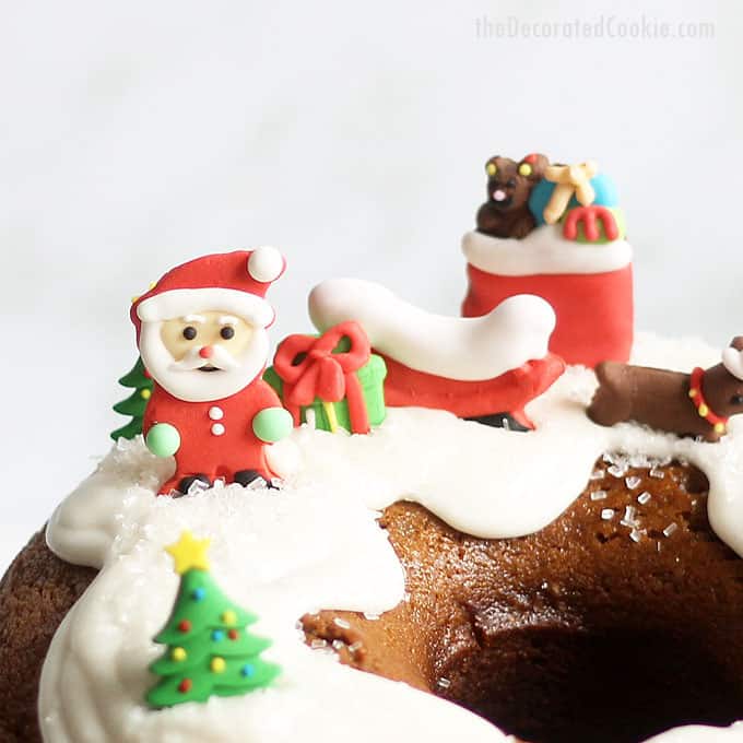 GINGERBREAD BUNDT CAKE with icing decorated with Santa, reindeer, presents, and as a gingerbread house for Christmas. 