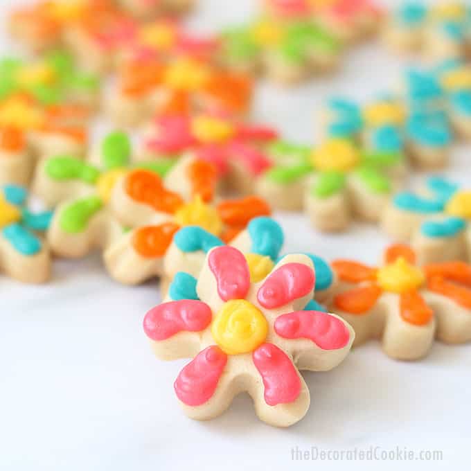 How to decorate MINI DAISY COOKIES with royal icing on cut-out sugar cookies. Colorful flower cookies for Spring or Mother's Day. Package in mason jars for a homemade gift idea. 