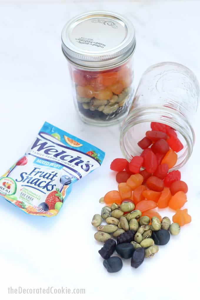 filling view of rainbow snack mix mason jars 