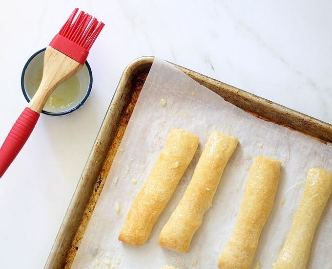 brushing butter on bread sticks