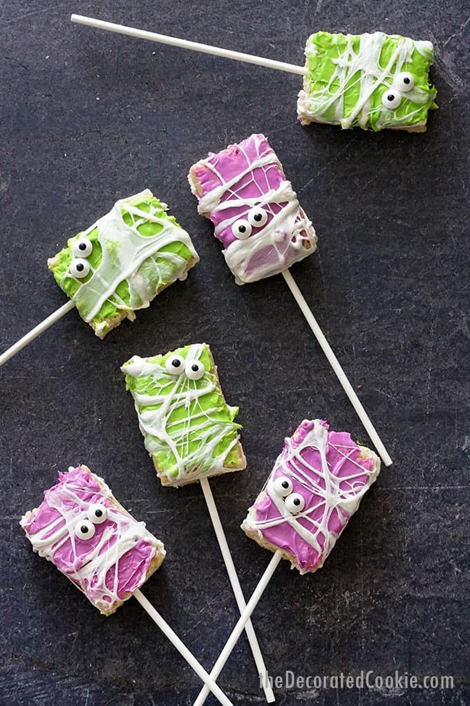 overhead image of purple and green halloween rice krispie treats on sticks 