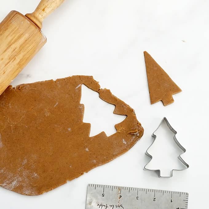 rolled out gingerbread cookie dough cutting out Christmas trees 