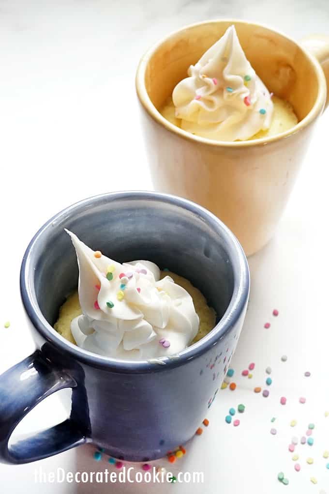 vanilla microwave mug cakes with frosting and spoon 